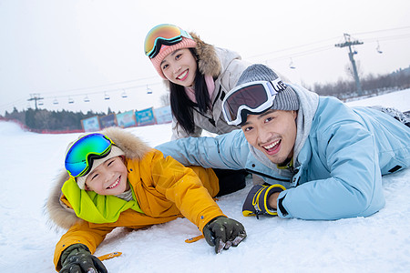 妈妈抱着儿子一家人一起去滑雪场滑雪背景