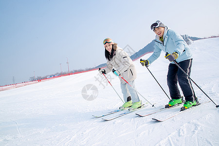 非都市风光休闲活动女朋友快乐的青年伴侣在滑雪场滑雪图片