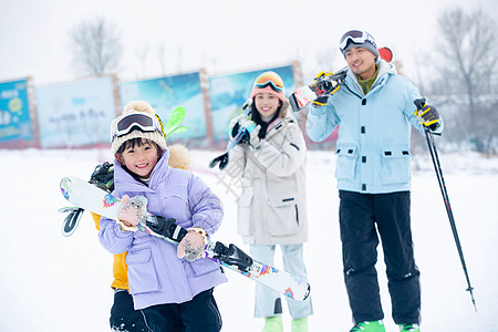 休闲活动放松非都市风光雪场上拿着雪具去滑雪的一家四口图片