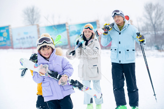 休闲活动放松非都市风光雪场上拿着雪具去滑雪的一家四口图片