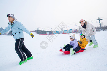 儿童奔跑带儿子女儿冬日滑雪的父母背景