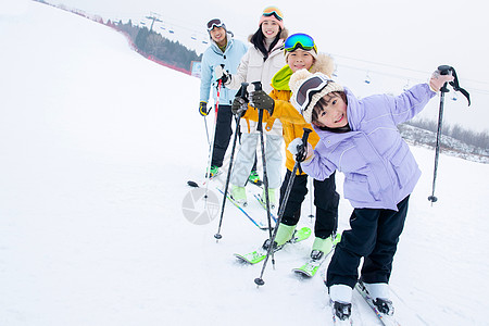 带帽子男孩带儿子女儿冬日滑雪的父母背景