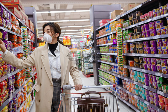 戴口罩的青年女人在超市购物图片