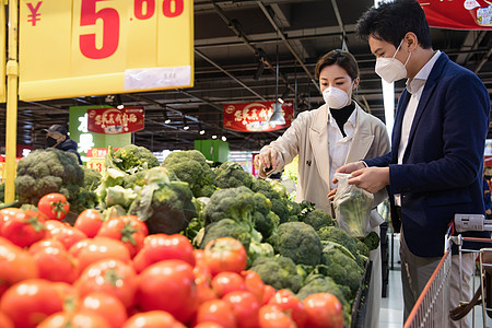 预防新型冠状青年夫妇戴口罩在超市挑选蔬菜图片