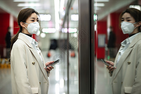 年轻女人站在地铁站台上图片