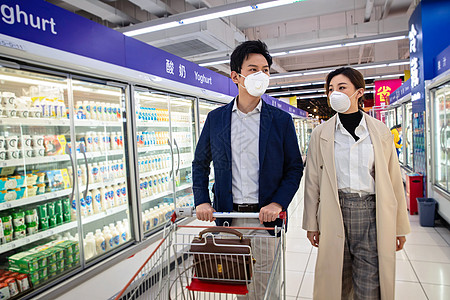防疫防护戴口罩的青年夫妇在超市购物图片