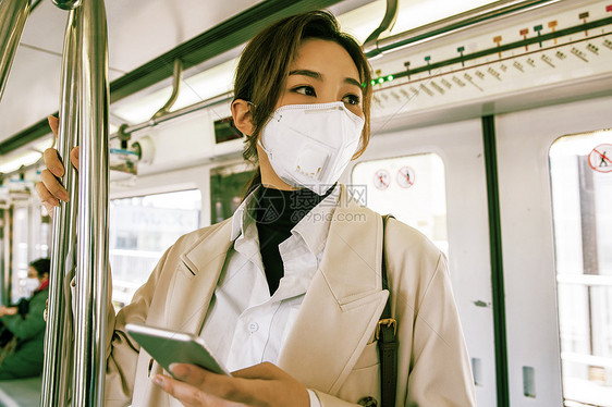 青年人戴口罩的年轻女人乘坐地铁图片
