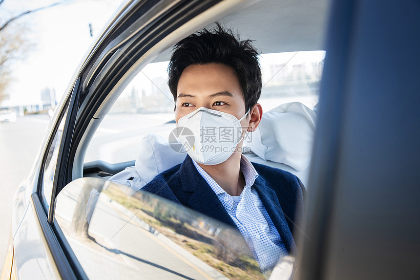 年轻男人戴口罩乘坐汽车图片