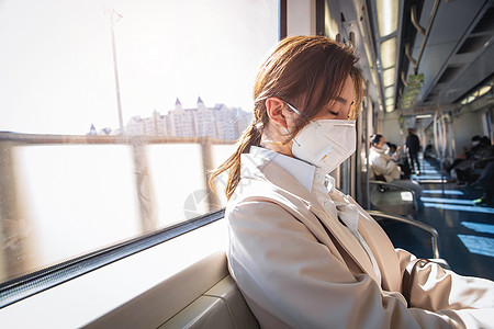疫情预防新型冠状新型冠状年轻女人戴口罩坐地铁高清图片