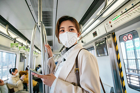 北京雾霾预防新型冠状交通方式戴口罩的年轻女人乘坐地铁背景
