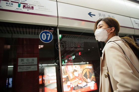 年轻女人站在地铁站台上图片