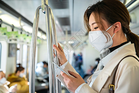 职业青年女人在地铁上看手机图片