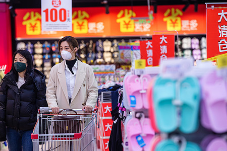 戴口罩的青年女人在超市购物图片