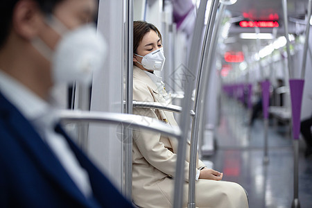 城市年轻女人戴口罩坐地铁图片