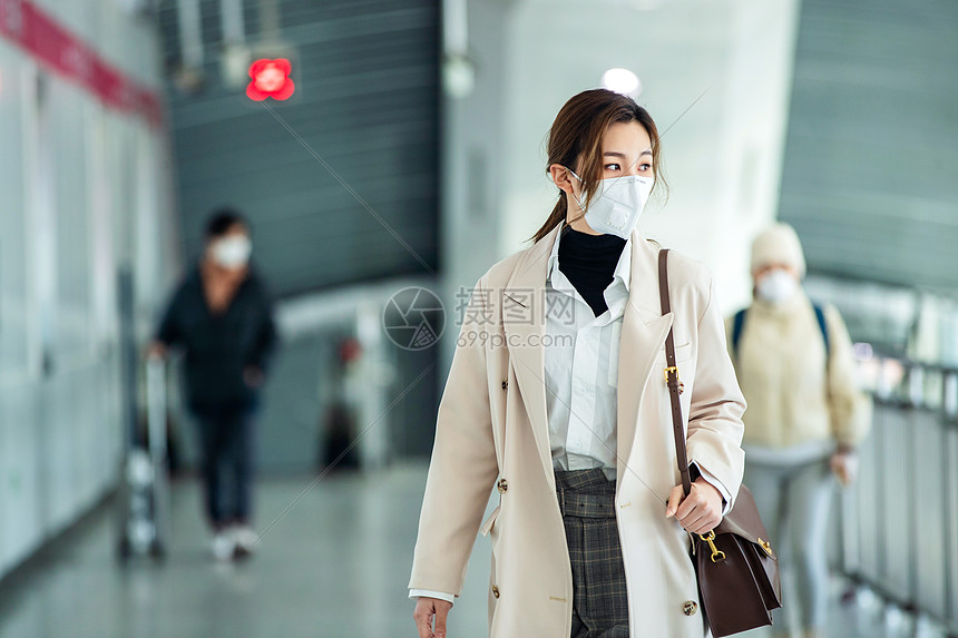 戴口罩的年轻女人走在地铁站里图片