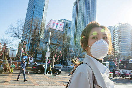 城市青年女人戴口罩在户外行走图片