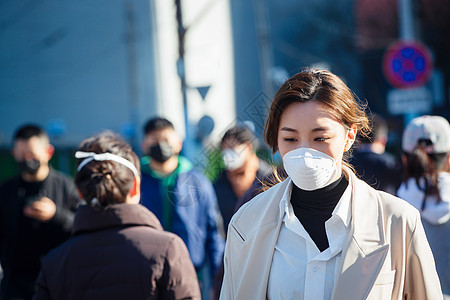 青年女人戴口罩在户外行走图片