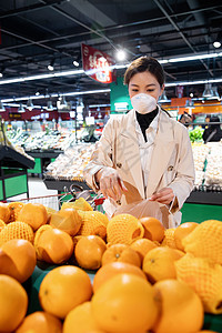 消费戴口罩的青年女人在超市挑选水果图片