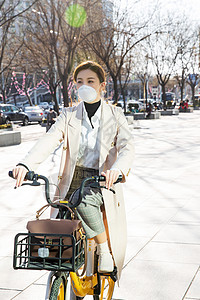 防流感口罩保护新型冠状戴口罩的年轻女人骑共享单车图片
