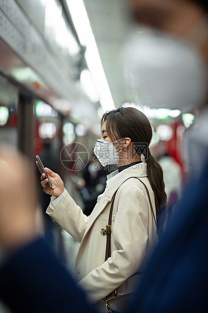 戴口罩的年轻女人在地铁里看手机图片