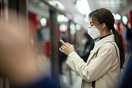 戴口罩的年轻女人站在地铁站台上图片