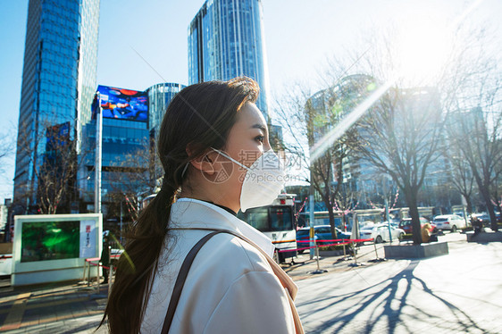 青年女人戴口罩在户外行走图片