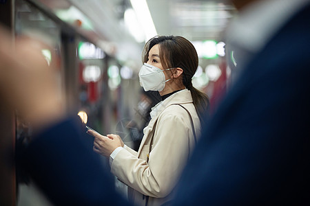 全国交通安全日戴口罩的年轻女人站在地铁站台上背景