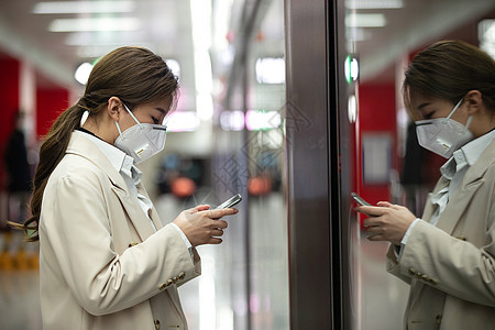 戴口罩的年轻女人站在地铁站台上图片