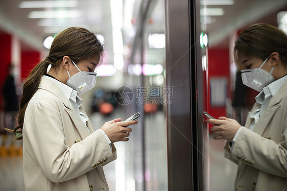 戴口罩的年轻女人站在地铁站台上图片