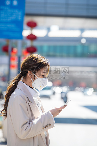 戴口罩的青年女人看手机图片