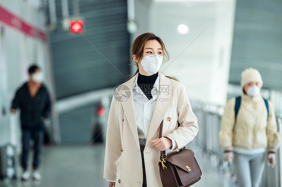 戴口罩的年轻女人走在地铁站里图片