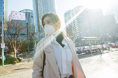 青年女人戴口罩在户外行走图片