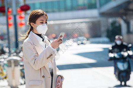 白领防护戴口罩的青年女人看手机高清图片