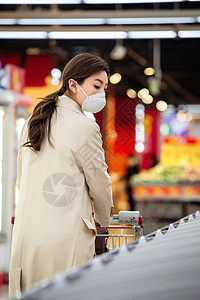 戴口罩的青年女人在超市购物图片