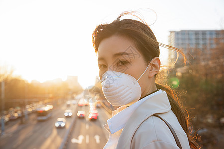 青年女人戴口罩在户外行走图片