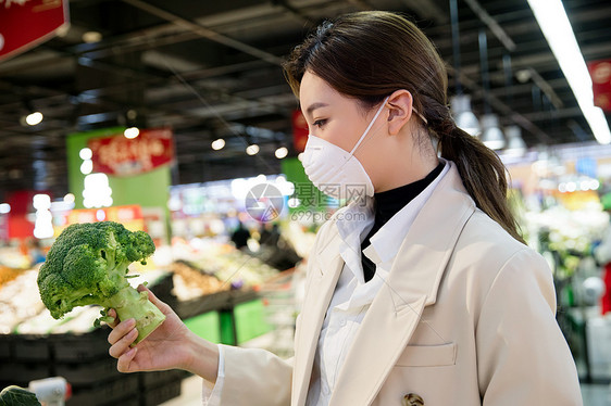 疫情生活戴口罩的青年女人在超市购买蔬菜图片