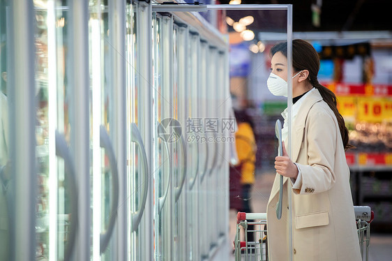 戴口罩的青年女人在超市购物图片