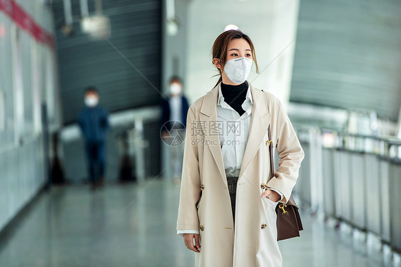 地铁月台戴口罩的年轻女人走在地铁站里图片