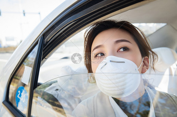 年轻女人戴口罩乘坐汽车图片