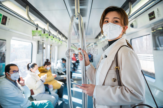 城市戴口罩的年轻女人乘坐地铁图片