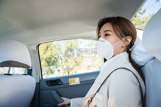 年轻女人戴口罩乘坐汽车图片