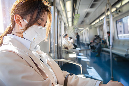 防污染口罩面罩白昼戴口罩的年轻女人在地铁上睡觉图片素材