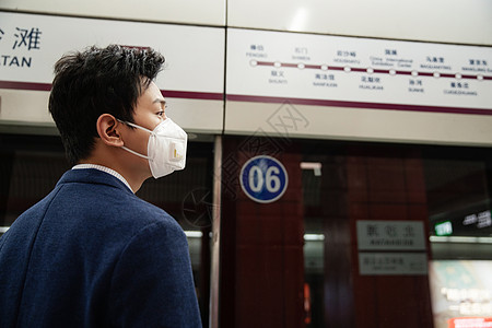 戴口罩的青年男人站在地铁站台上图片