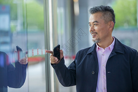 商务男士看橱窗反射的自己图片