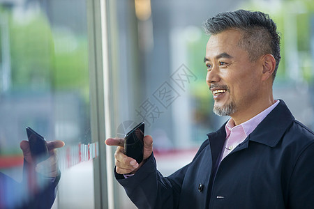 商务男士看橱窗反射的自己图片