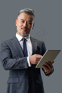 商务中老年男士拿着平板电脑图片