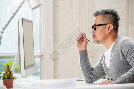 在室内研究图纸的中老年设计师男士图片