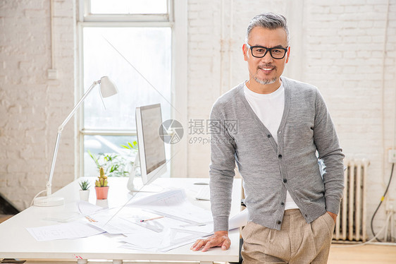 在室内研究图纸的中老年设计师男士图片