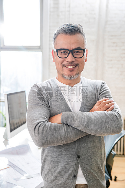 在室内研究图纸的中老年设计师男士图片