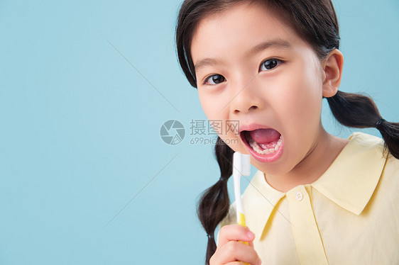 卫生保健和医疗快乐休闲装拿着牙刷刷牙的小女孩图片